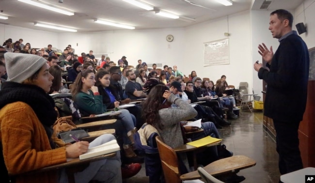 In this Wednesday Feb. 1, 2017, photo, Brooklyn College chemistry professor Alexander Greer, right, lectures during his class, in New York. (AP Photo/Bebeto Matthews)