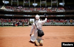 A supporter prays before the arrival of Kenya's President Uhuru Kenyatta at the Kasarani stadium for the official launch of the Jubilee Party ahead of the 2017 general elections in Kenya's capital Nairobi, Sept. 10, 2016.