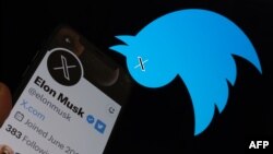 This illustration photo taken on July 24, 2023 shows the Twitter bird logo upside down in the background of Elon Musk’s screen advertising an "X" as a replacement logo, in Los Angeles.