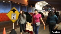 Mujeres cruzan la frontera de Estados Unidos con México con un bebé en el cruze fronterizo de Nogales, Arizona, Estados Unidos, 30 de enero de 2017.