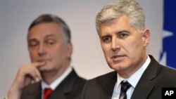 Dragan Covic , right, leader of "Croatian Democratic Union" (HDZ), and Zlatko Lagumdzija , left, leader of Social Democratic party (SDP) address journalists during press conference in Sarajevo, Bosnia, on Wednesday, Dec. 28, 2011. After more than a year o