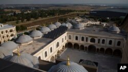 FILE - Solar panels work on the roof of the Nizamiye Mosque in Midland Johannesburg, April 5, 2023