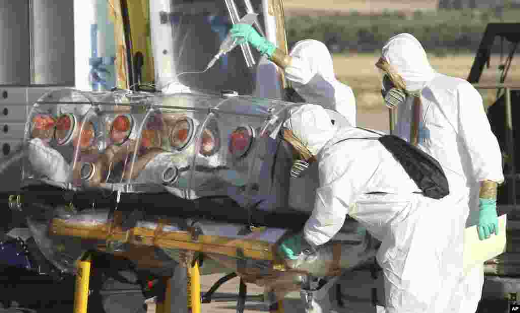 Aid workers and doctors transfer Miguel Pajares from a plane to an ambulance as he leaves the Torrejon de Ardoz military airbase, near Madrid, Spain, Aug. 7, 2014.