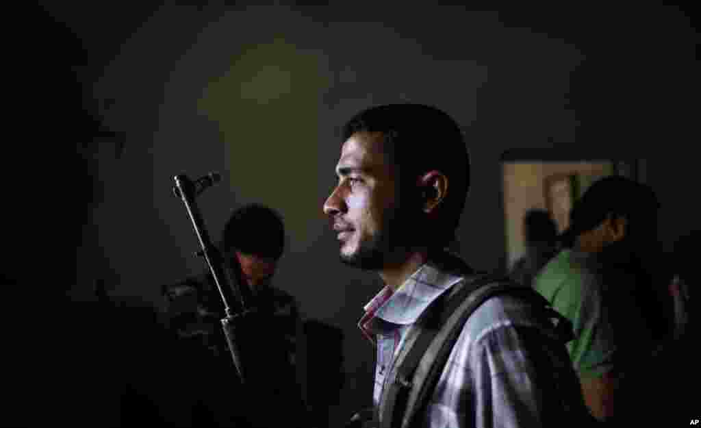 A Syrian rebel fighter holds his rifle as he and other fighters head to Aleppo to fight government forces, at their headquarters in Suran, on the outskirts of Aleppo, Syria, September 10, 2012.