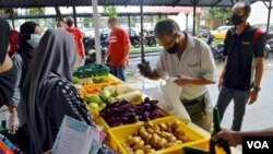 A man selects fresh produce at a mobile food bank run by Kechara in Kuala Lumpur. (Zsombor Peter/VOA)