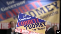 A supporter holds up a campaign sign as Pennsylvania Republican gubernatorial candidate Tom Corbett, Lt. Gov. candidate James Cawley and Pennsylvania Republican Senate candidate Senate Pat Toomey, appear during a rally in Pa., 01 Nov. 2010.