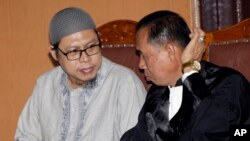 Zainal Anshori (kiri), perwakilan dari JAD, didampingi oleh pengacaranya, mengikuti sidang vonis terhadap JAD di Pengadilan Negeri Jakarta Selatan, Selasa (31/7).