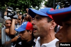 FILE - Venezuela opposition leader Henrique Capriles confronts security forces at an anti-government rally in Caracas, Venezuela, May 12, 2017.