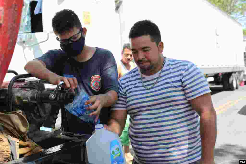 Algunos transportistas toman agua gratis proporcionada por la Cruz Roja.