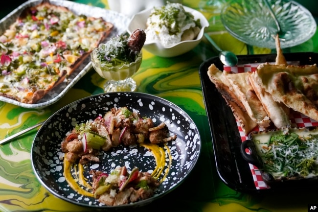 Multiple dishes are shown at a table at Shuggie's Trash Pie restaurant in San Francisco on June 14, 2023. (AP Photo/Jeff Chiu)