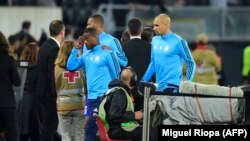 Patrice Evra, au centre, quittant l'ère de jeu après un incident avec un supporter avant le match Guimaraes - OM en Eourpa League au stade Afonso Henriques, le 2 novembre 2017. AFP PHOTO / MIGUEL RIOPA