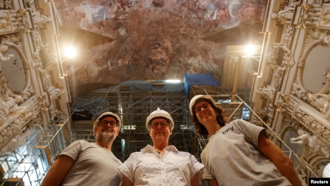 Jose Luis Regidor, restorer and director of the project, joins Pilar Roig Picazo and Pilar Bosch Roig for a picture at the Church of Santos Juanes, in Valencia, Spain, September 16, 2024. (REUTERS/Eva Manez)