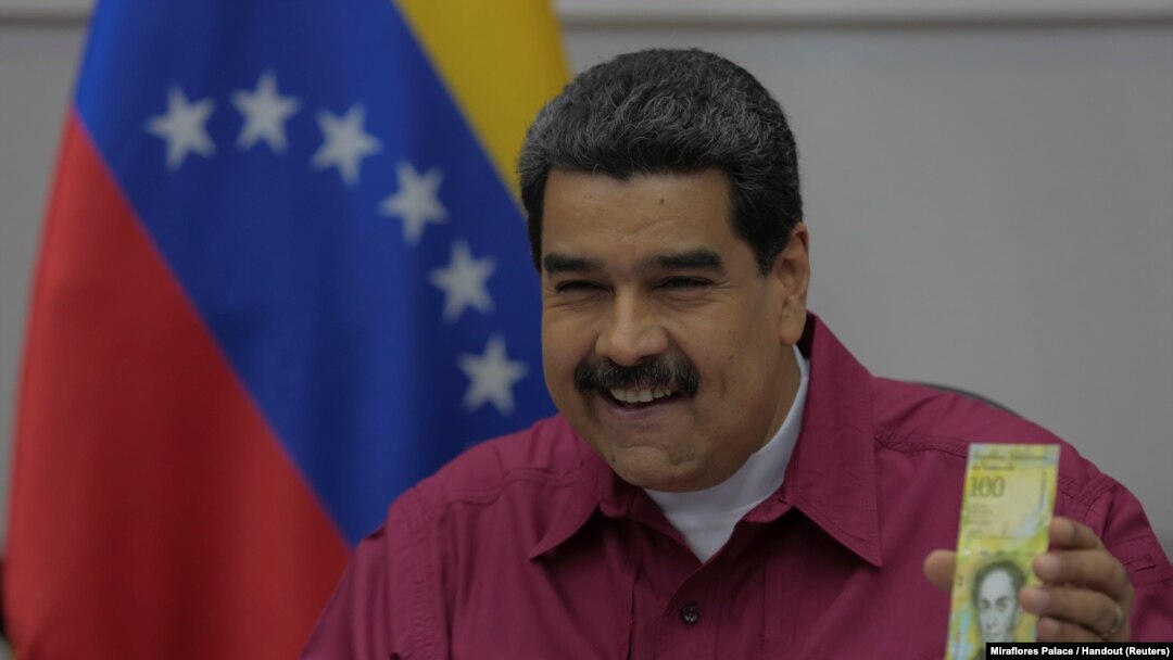 Presiden Venezuela Nicolas Maduro memegang uang kertas 100.000 bolivar ketika berbicara dalam sebuah pertemuan dengan para menteri di Caracas, Venezuela, 1 November 2017. 