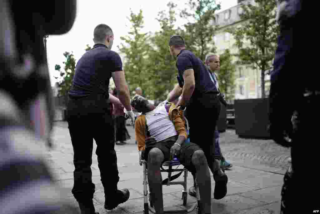 A protester is evacuated by firefighters during a demonstration of undocumented migrants asking for the regularization of their situation, in Paris, France.