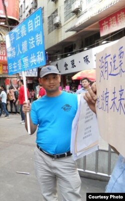 杨崇去年三月在广州街头参与公民举牌活动(微博图片)