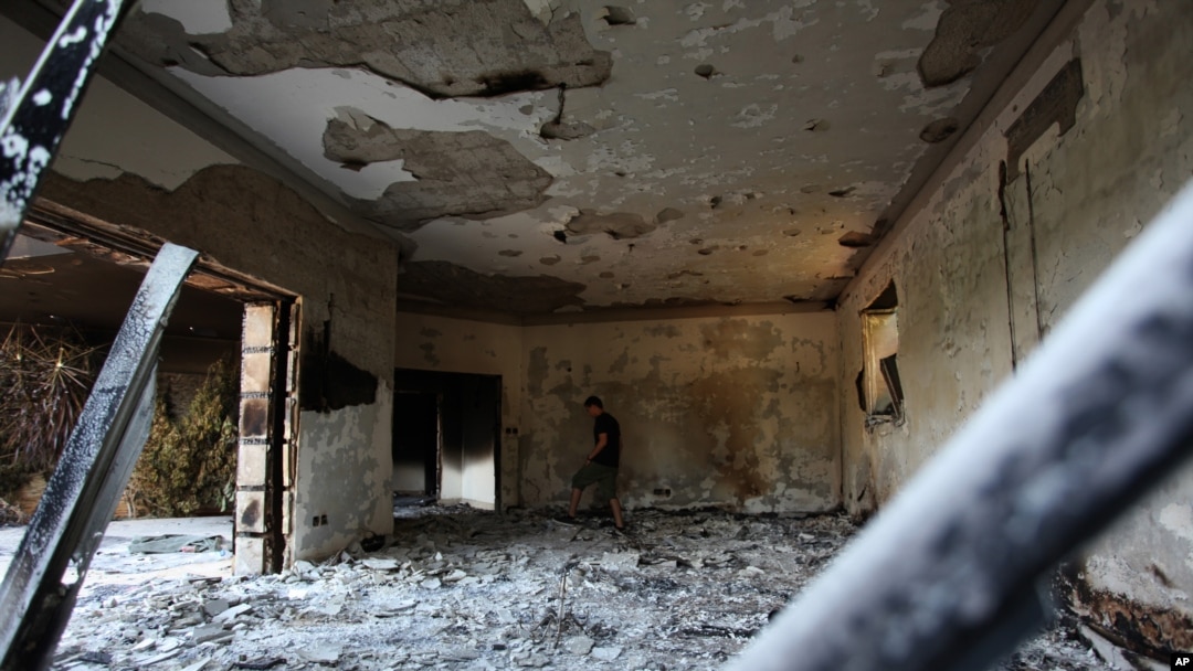 Seorang pria Libya berjalan di reruntuhan Konsulat Amerika di Benghazi, Libya.