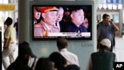 South Korean passengers watch a news reporting about the North Korea's army chief Ri Yong Ho's departure on a TV screen at the Seoul train station in Seoul, South Korea, July 17, 2012.