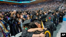 FILE - UCLA students celebrate during a commencement ceremony inside Pauley Pavilion on UCLA campus, in Los Angeles, June 14, 2024.