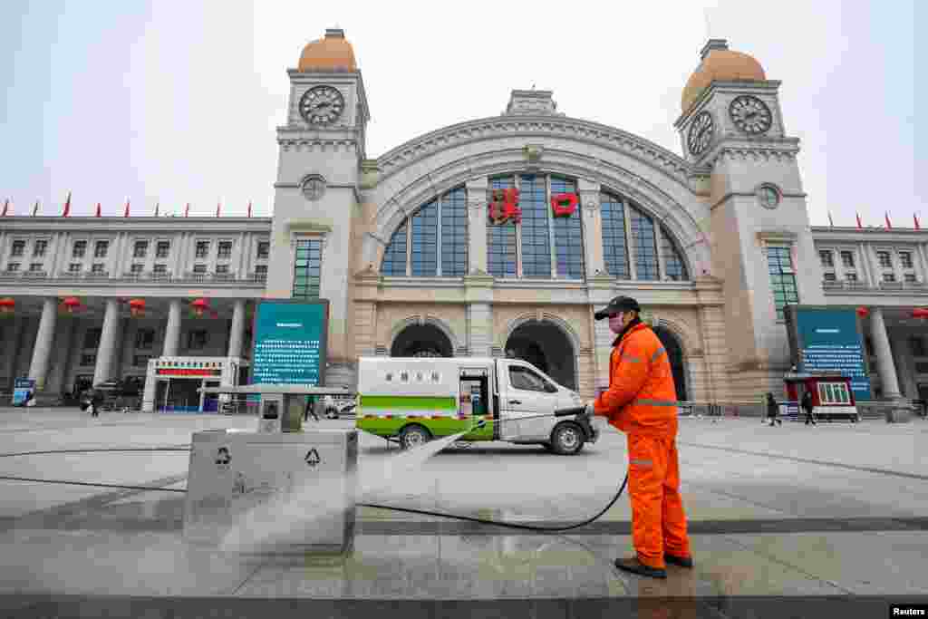 Seorang pekerja yang mengenakan masker melakukan sanitasi di alun-alun depan Stasiun Kereta Api Hankou, yang ditutup setelah kota Wuhan dikarantina oleh pemerintah China karena merebaknya virus corona baru, di kota Wuhan, provinsi Hubei.