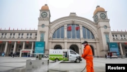 A worker sanitizes the square in front of the Hankou Railway Station, closed after the city of Wuhan was locked down following the outbreak of a new coronavirus, in Wuhan, Hubei province, China Jan. 23, 2020.