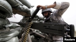 A Saudi soldier loads ammunition at their position at Saudi Arabia's border with Yemen, April 6, 2015. 