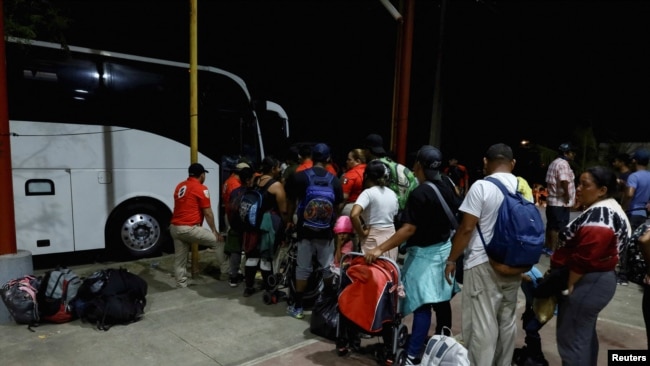 Migrants queue to board a bus bound to Huixtla, to continue their procedures and obtain a migration form that will allow them to transit through Mexico and reach the northern border, in Mapastepec, Mexico, Jan. 2, 2024.
