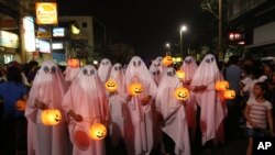 People wear ghost costumes as they join a Halloween Parade in the Philippines, 2013. (AP Photo/Aaron Favila)