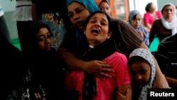 Tin Tin Kyaw (2nd R) cries near the body of her husband Soe Min, a 51-year-old man who was killed in a recent riot, at a mosque in Mandalay July 3, 2014.