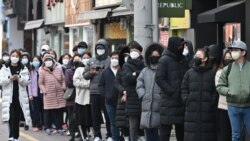 Güney Kore'de maske satın almak için sıraya giren insanlar