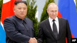 Владимир Путин и Ким Чен Ын пожимают друг другу руки во время встречи во Владивостоке, Россия, 25 апреля 2019