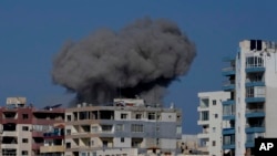 Asap membubung dari gedung-gedung yang terkena serangan udara di pusat Kota Tyre, selatan Lebanon, Jumat, 22 November 2024. (Foto: Hussein Malla/AP Photo)