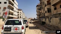 FILE - A June 1, 2016 photo released by the International Committee for the Red Cross shows the first humanitarian aid convoy in Daraya, Syria. 