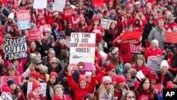 Thousands of teachers wearing red surround the Statehouse in Indianapolis, Indiana, Nov. 19, 201a9 for a rally calling for further increasing teacher pay in the biggest such protest in the state. 
