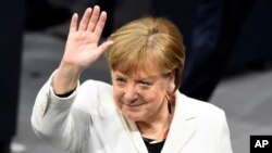 La canciller alemana, Angela Merkel, saluda cuando el parlamento se reunió para elegirla para un cuarto mandato el miércoles, 14 de marzo de 2018, en Berlín, Alemania.