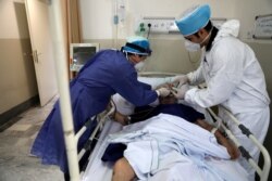 FILE - Medics tend to a COVID-19 patient at the Shohadaye Tajrish Hospital in Tehran, Iran, June 16, 2020.