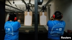 Nicole Navarro (kiri) dan Adriana Retana, yang giat berlatih menembak di sebuah sarana pelatihan menembak di El Paso, Texas, pasca penembakan di Walmart yang menewaskan 22 orang, 12 Agustus 2019. (REUTERS/Julio-Cesar Chavez)