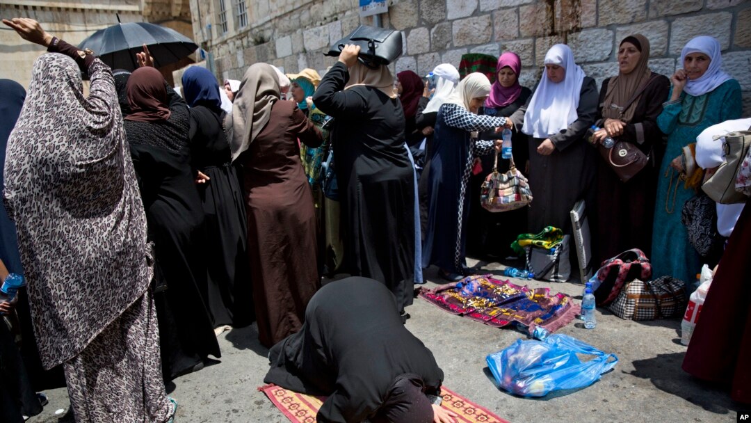 Para Muslimah Palestina melakukan sholat dan doa bersama di luar 'Pintu Gerbang Domba' di komplek Kota Tua Yerusalem, Selasa (25/7). 
