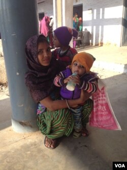 Suman, who goes by one name only, is waiting at a polling station with her two young children and says she will stamp on the flower - the lotus symbol of the Bharatiya Janata Party. (A. Pasricha/VOA)