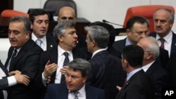 FILE - Turkish legislators from Prime Minister Recep Tayyip Erdogan's ruling party and the main opposition Republican People's Party brawl during a tense all-night debate over a controversial law on changes to a council that appoints and overseas judges a