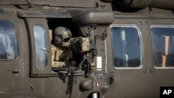 A helicopter gunner waits for takeoff at a U.S. military base at an undisclosed location in eastern Syria, Nov. 11, 2019. 