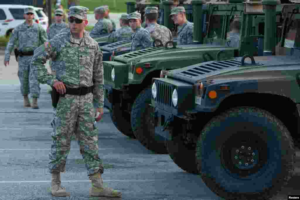 National Guard troops arrive at a mall complex that serves as staging area for the police in Ferguson, Missouri, Aug. 18, 2014.