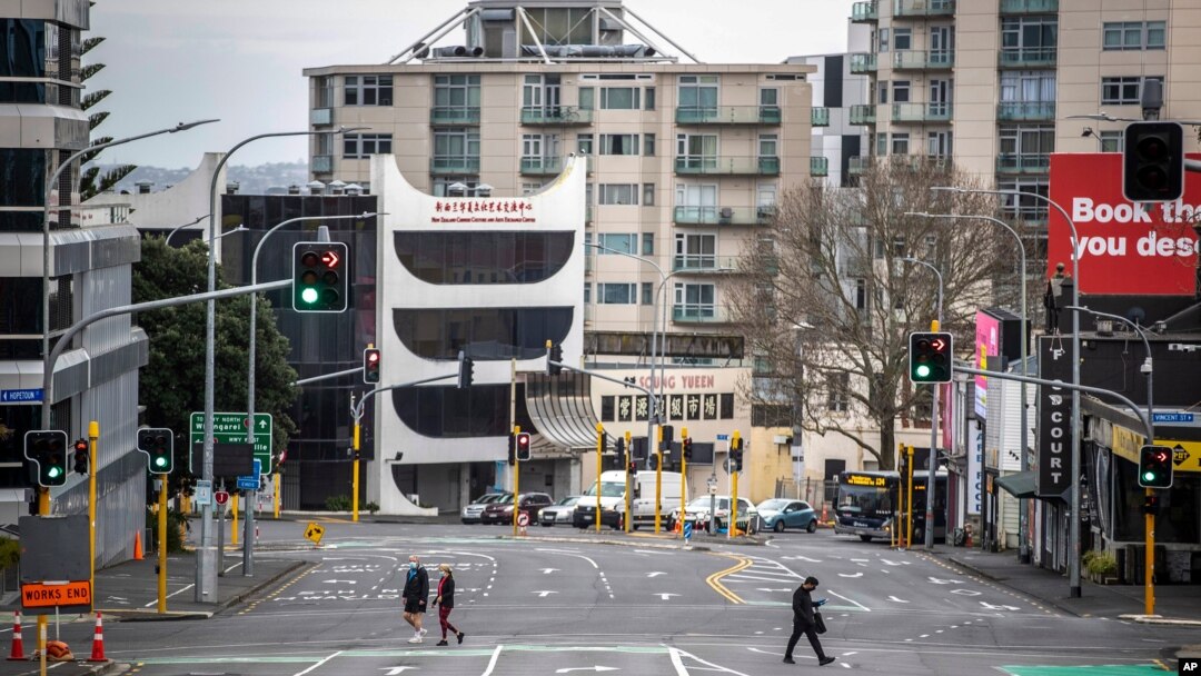 Warga menyeberangi jalanan yang sepi di tengah pembatasan wilayah di pusat bisnis Auckland, Selandia Baru, 27 Agustus 2021. (Michael Craig/NZ Herald via AP)