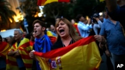 Anti-independence demonstrators waving Spanish flags shout slogans during a protest in Barcelona, Oct. 4, 2017.