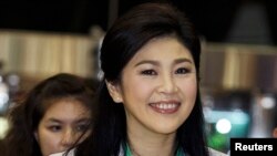 FILE - Former Thai Prime Minister Yingluck Shinawatra smiles as she arrives at Bangkok's Suvarnabhumi Airport, July 23, 2014.