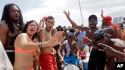 FILE - Spring breakers dance and sing to music in the South Beach area of Miami Beach, Florida, March 14, 2016. 