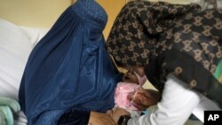 File - A child receives a measles vaccine at the Indira Gandhi Children Hospital, in Kabul, Afghanistan, March 15, 2021.
