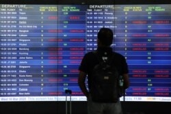 A man looks at an information board displaying cancelled flights after Malaysia’s government closed its borders due to the spread of the coronavirus, at Kuala Lumpur International Airport, in Sepang, Malaysia, March 18, 2020.