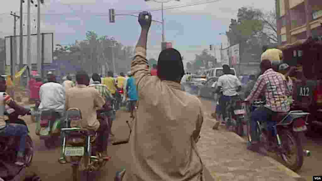 People on motorbikes follow Al-Mustapha as he arrives in Kano.