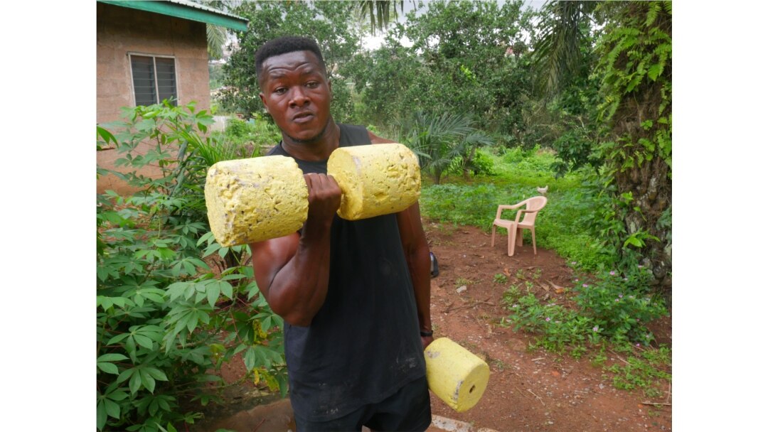Bodybuilder Samuel Kulbila has gained an international following from posting videos of workouts done with improvised equipment, like concrete weights. Accra, Ghana, July 5, 2020. (Stacey Knott/VOA)