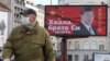 塞尔维亚一名戴着口罩的男子走过贝尔格莱德街头树立的感谢中国领导人习近平的广告牌旁。（2020年4月1日）